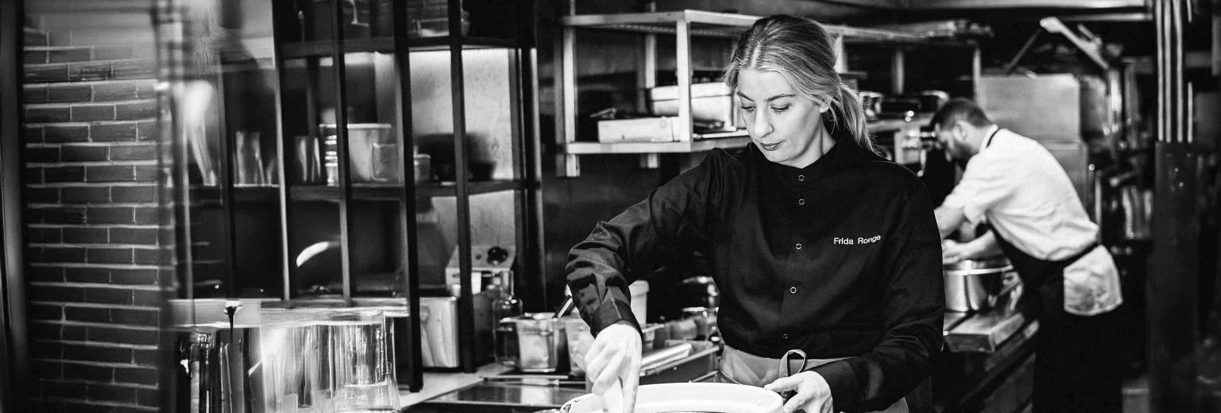 Kvinna lagar mat i i ett restaurangkök