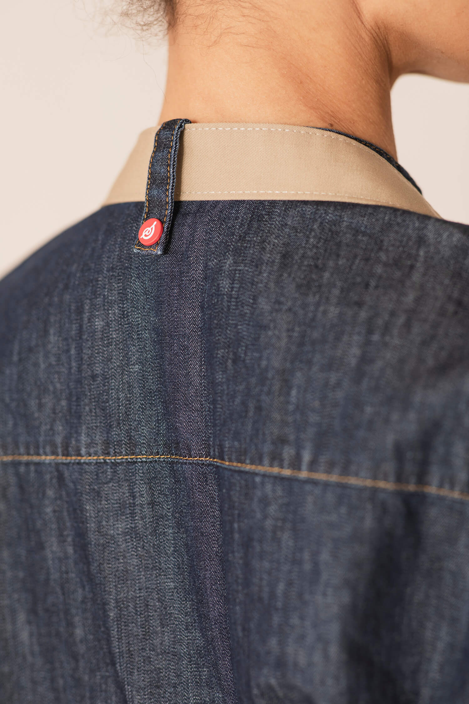 En ny kockrock i denim från Segers, modell 1097, med den distinkta nya Segers-knappen placerad i nacken som en elegant detalj.