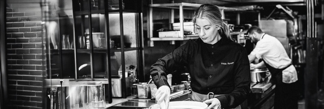 Kvinna lagar mat i i ett restaurangkök